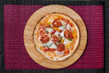 A delicious Mexicana Pizza on a wood plate.