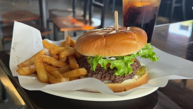 Juicy freshly made hamburger with fries at a diner - isolated