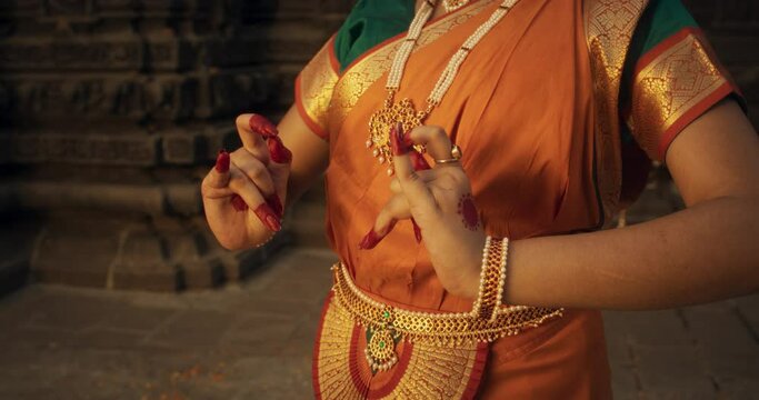 Close-Up Arc Shot of the Hands of an Indian Female Dancer Displaying Symbolic Gesture, Conveying Messages in Folkloric Dance. Girl in Traditional Sari Showcasing the Art of Mudras Movement