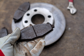 Car mechanic checking asbestos brake pads