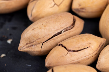 cracked unpeeled pecans close-up on the table