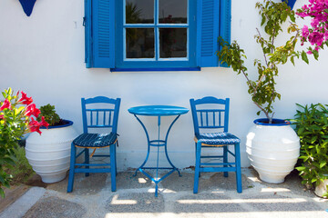 typical greek outdoor still live with blue table and chairs