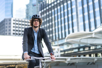 Portrait of hipster handsome businessman in suit with backpack looking forward while commuting riding bicycle on the street city way go to work.business travel transport bike concept