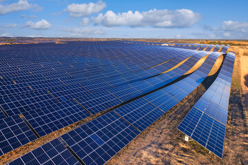 Solar park with large solar panels in the countryside under blue sky with clouds. Solar power...