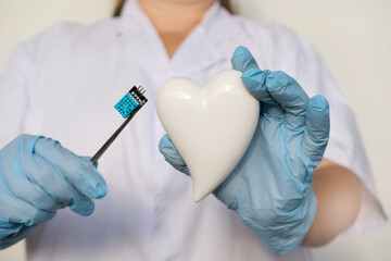 female scientist, doctor holding heart model, microprocessor, microchip, biochip tweezers for...