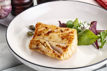 Roasted cod fish steak with salad