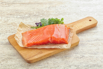 Raw salmon fillet over board