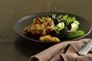 Roasted turkey thigh with green salad and blackberries, served with french mustard, copy space