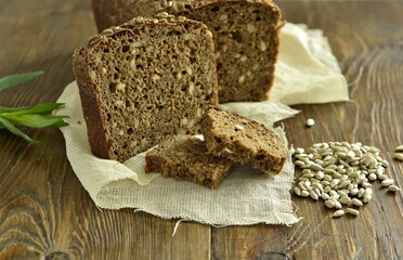 Homemade sourdough rye bread with sunflower seeds on rustic wooden background. Healthy nutrition