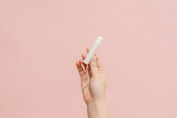 Medical feminine tampon in hand. Cotton swab. Menstruation