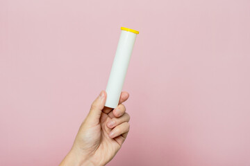 Hand holding bottle for pills, effervescent tablets or vitamin