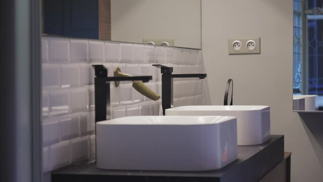 Slow revealing shot of a double vanity unit within a bathroom with a large mirror