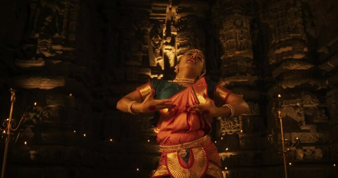 Dramatic Performance Done by an Indian Girl Practicing the Art of Bharatanatyam in an Ancient Temple. Expressive Young Female in Colourful Traditional Sari Dancing Folk Dance Choreography