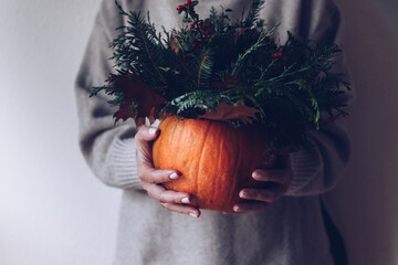 Rich autumn bouquet with a pumpkin in the hands of a girl on a light background