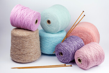 composition of bobbins with woolen threads, yarn for knitting close-up on a white background