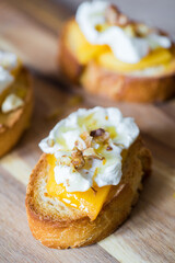 Baguette slices with cream cheese, persimmon, honey, and nuts