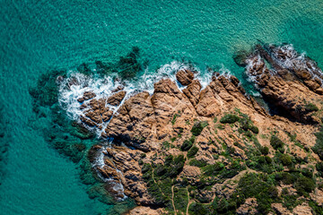 Aerial view of beautiful rocky coast. Turquoise sea and rocks.  Drone Top down view of sea crystal water and cliffs shore, South Sardinia, Italy.  Mediterranean Sea.