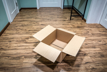 Empty cardboard box on tilled floor
