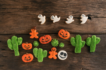 Sweets for Halloween. Homemade cookies in the form of ghosts, cacti and pumpkins Jack-o-lantern on wooden background.