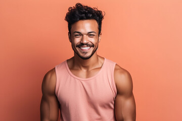 Obraz premium Muscular brunette guy smiling at the camera on a pink background. Generative AI.