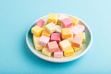 Various fruit jelly chewing candies on blue pastel. apple, banana, tangerine, side view.