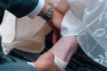 Groom helping bride in wedding high heels