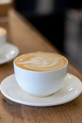 Cappuccino on table in a cafe.a cup of latte coffee on wooden vintage table.