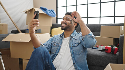 African american man having video call holding key at new home