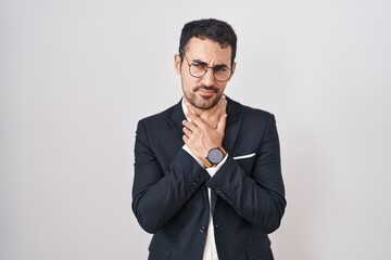 Handsome business hispanic man standing over white background touching painful neck, sore throat for flu, clod and infection