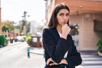 Young beautiful hispanic woman standing with doubt expression at street