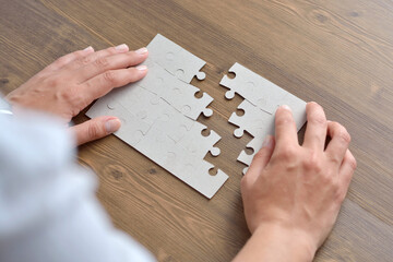Image of businesswoman connecting elements of white puzzle - 632128188