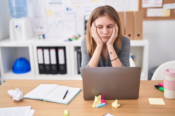 Young blonde woman business worker using laptop with boring expression at office