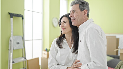 Obraz premium Senior man and woman couple smiling confident hugging each other at new home