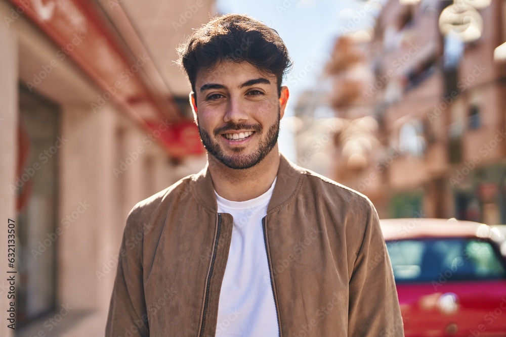 Wall mural young hispanic man smiling confident standing at street