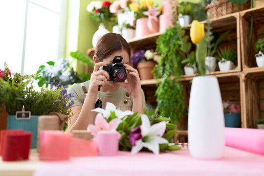 Young beautiful woman florist make photo to bouquet of flowers at flower shop