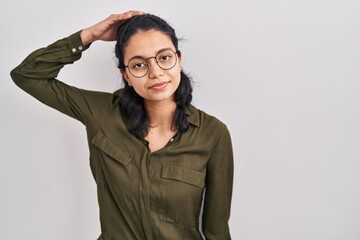 Hispanic woman with dark hair standing over isolated background confuse and wonder about question....
