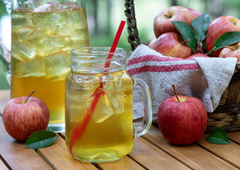 Apple juice in glass and pitcher with fresh apples