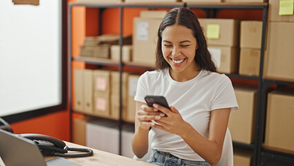 African american woman ecommerce business worker using smartphone smiling at office