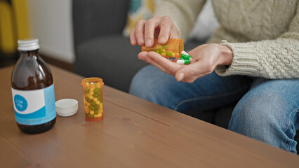 Mature hispanic woman taking pills at home