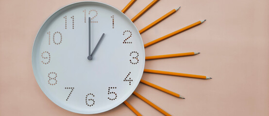 Banner with clock. 1 o'clock. Daytime. Study time. Back to school. Watch with white clock face on table background with pencils. lunchtime. Concept of online study, deadline, schedule, lunch break