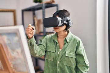 Young chinese woman artist using vr glasses drawing at art studio