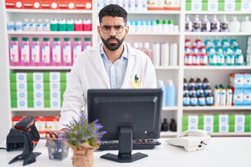 Hispanic man with beard working at pharmacy drugstore skeptic and nervous, frowning upset because of problem. negative person.