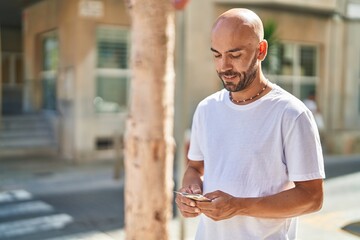 Young bald man smiling confident counting dollars at street