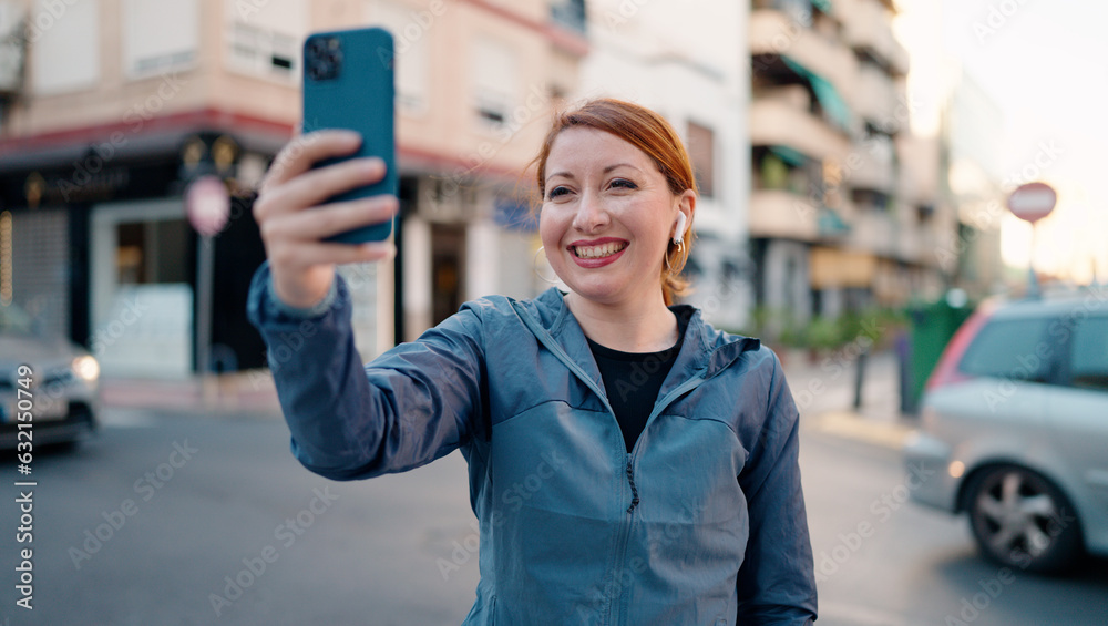 Sticker young redhead woman wearing sportswear make selfie by smartphone at street