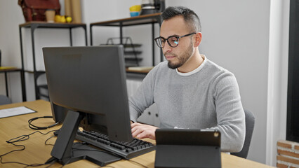 Hispanic man business worker using computer and tablet at office