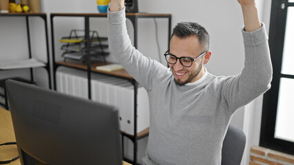 Fototapeta na wymiar Hispanic man business worker using computer celebrating at office