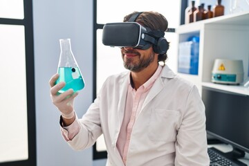 Middle age man scientist using virtual reality glasses holding test tube at laboratory