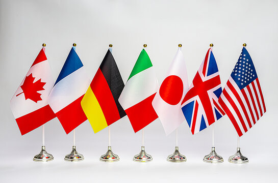 Office flags of the countries of the G7 block on a light background. Summit of USA, UK, Japan, Italy, Germany, France and Canada.