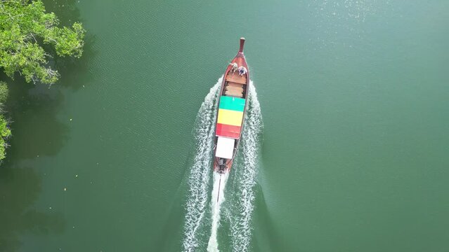 Aerial top view tourists women friends lie sunbathing in longtail boat float water green surface. Boat trip traditional rasta asian river water transport vessel. Travel tourism vacation recreation 4k