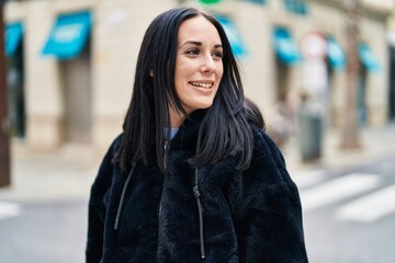 Fototapeta premium Young caucasian woman smiling confident looking to the side at street